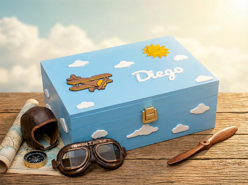 Scatola dei ricordi personalizzata a tema aviazione, con nome del bambino sul coperchio, aeroplano, sole sorridente e nuvole. Colore della scatola: azzurro.