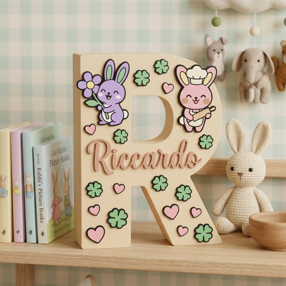 Lettera R in legno personalizzata con nome Riccardo, decorazione da appoggio per cameretta bambini. Arricchita con applicazioni in rilievo a tema coniglietti, cuori rosa e quadrifogli verdi.