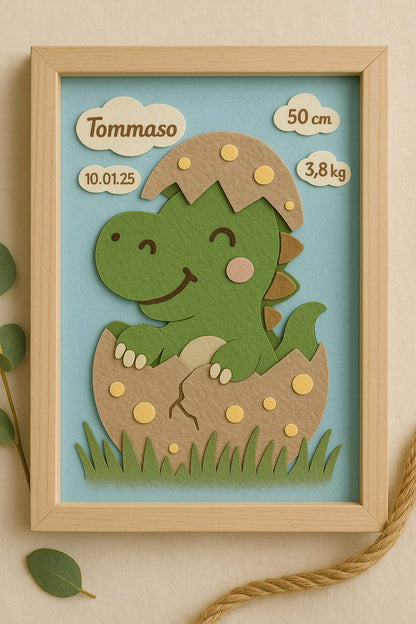 Quadretto nascita rappresentante un dinosauro che sta nascendo. Sono presenti anche i dati del bambino per il quale il quadretto è fatto.