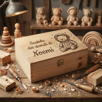 Scatola dei ricordi in legno personalizzata con incisione del nome Noemi e disegno di un orsetto astronauta, fotografata su un banco da lavoro artigianale tra trucioli di legno e attrezzi da intaglio.