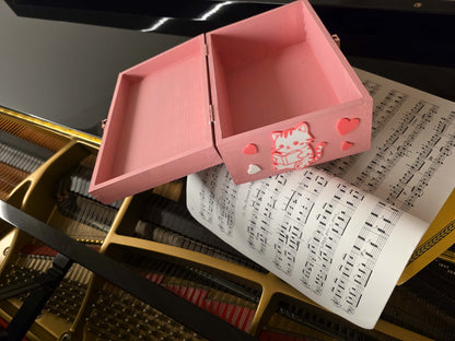 Scatola dei ricordi rosa aperta con decorazioni a gattini, perfetta per conservare ricordi di nascita e primi anni della bambina.