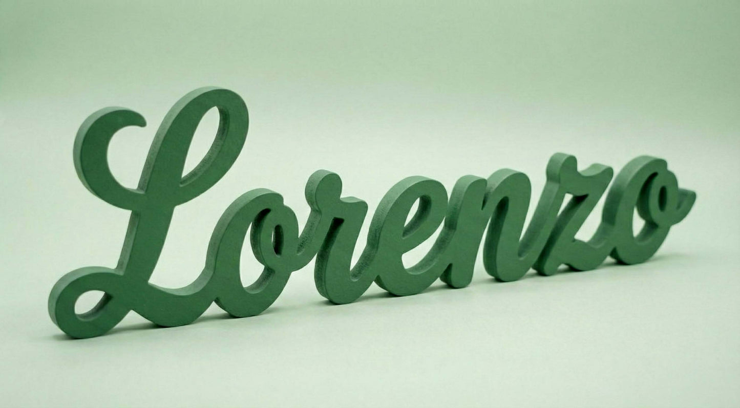 Scritta in legno verde personalizzata con il nome Lorenzo, autoportante, fotografata su sfondo semplice.
