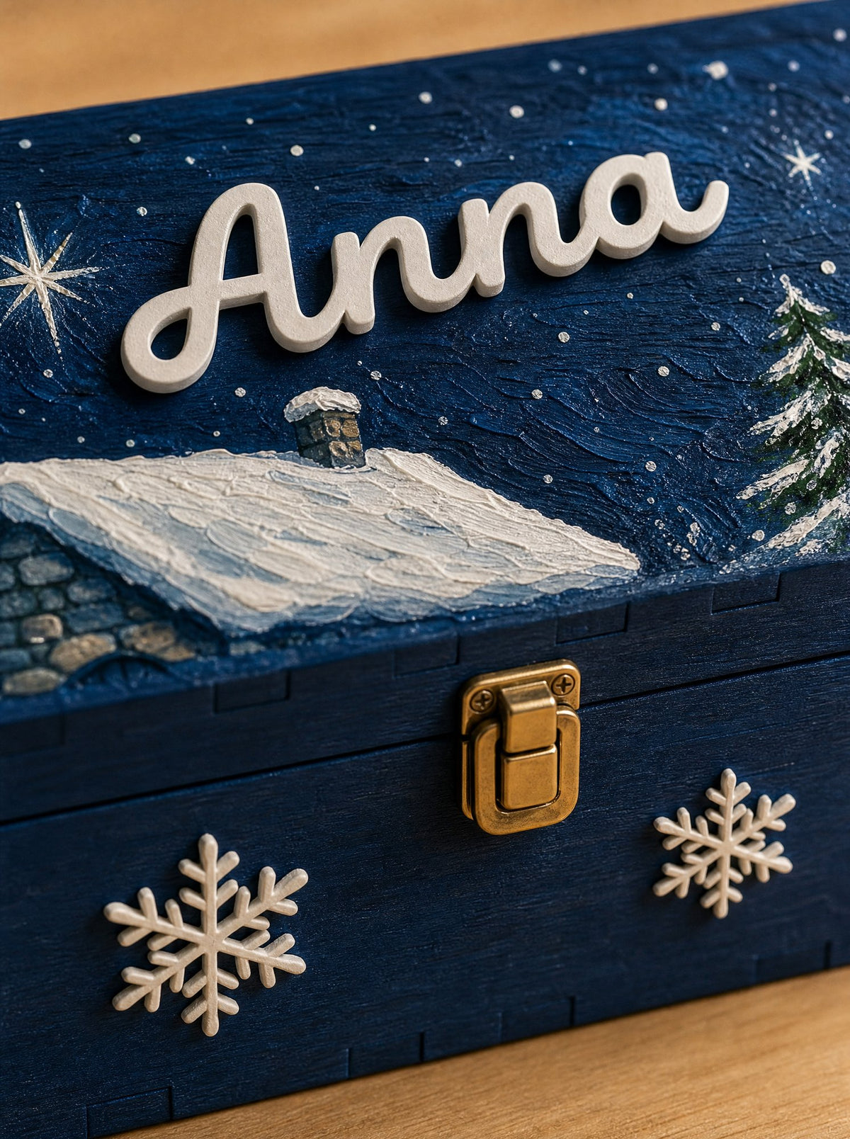 Dettaglio ravvicinato del nome Anna applicato in rilievo e dei fiocchi di neve sul fronte della scatola