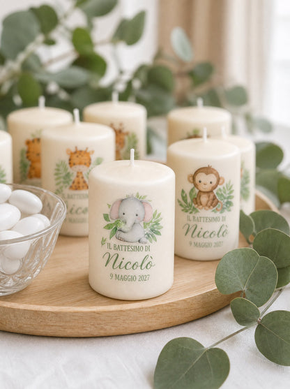 Candele battesimo su un vassoio di legno con rami di eucalipto e confetti, elefantino e scimmietta in primo piano
