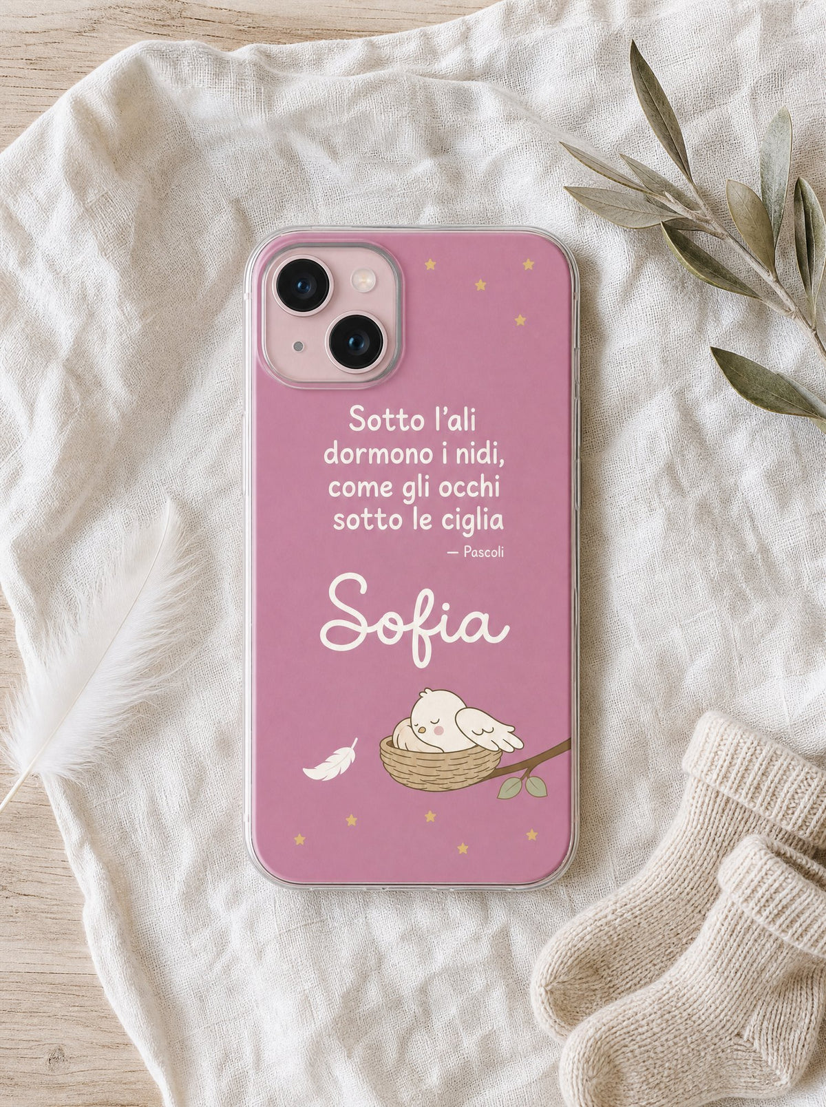 Cover per la mamma con un uccellino che dorme nel nido, frase di Pascoli e nome Sofia, su un iPhone 15 visto dall'alto