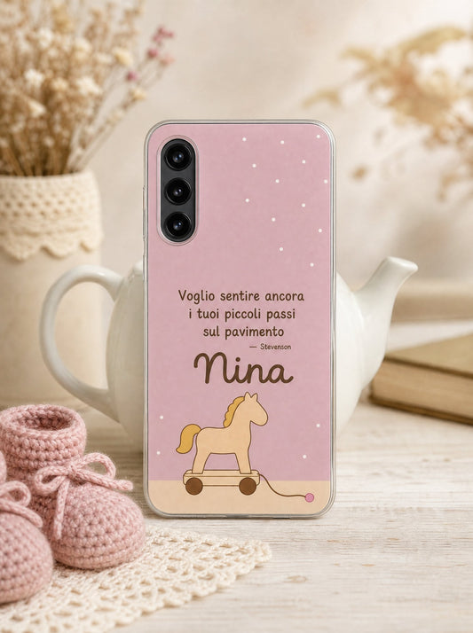 Cover con un cavallino di legno a rotelle e il nome Nina su un Samsung Galaxy S24 in piedi, ripresa di fronte