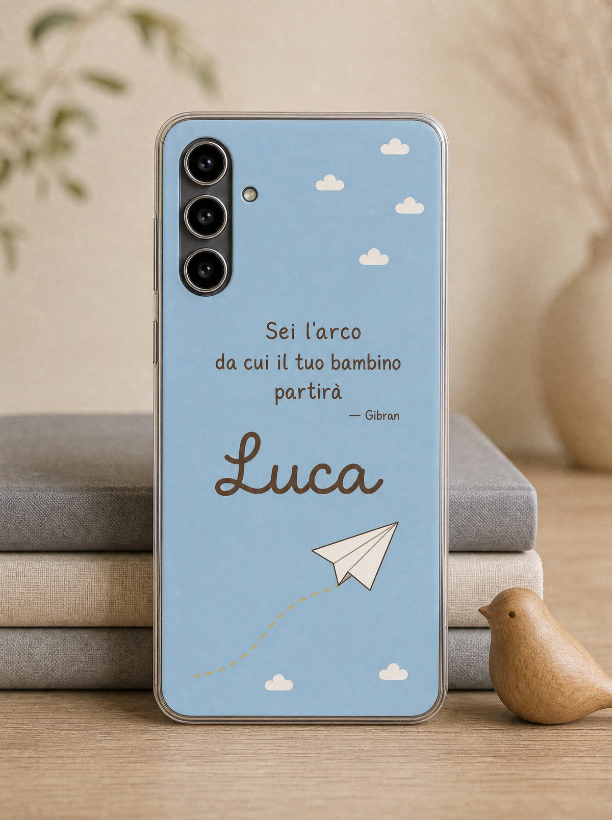 Cover con un aeroplanino di carta e il nome Luca su un Samsung Galaxy S24 in piedi, ripresa di fronte