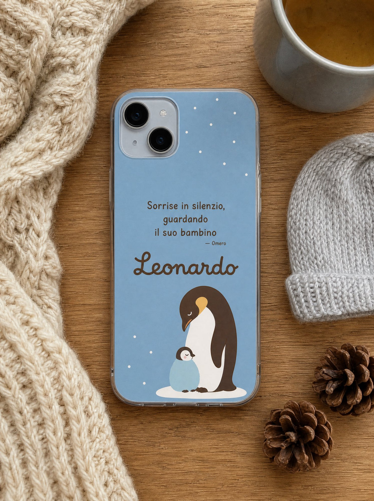 Cover per il papà con un papà pinguino col pulcino, frase di Omero e nome Leonardo, su un iPhone 15 visto dall'alto
