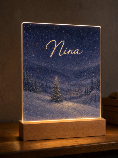 Scena Notte di neve con collina innevata e abete illuminato, nome Nina nel cielo stellato