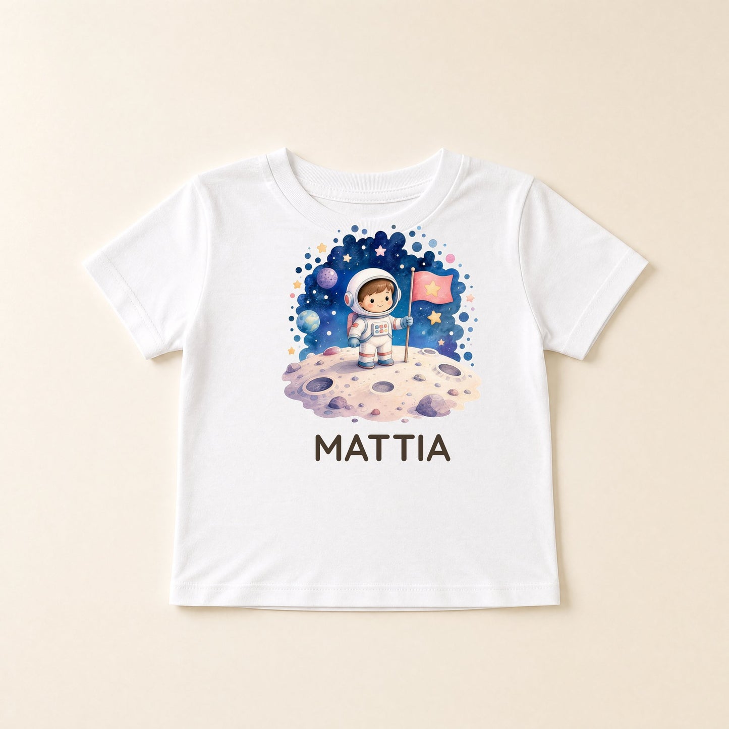 Maglietta bianca distesa con grafica a tema spazio e il nome Mattia
