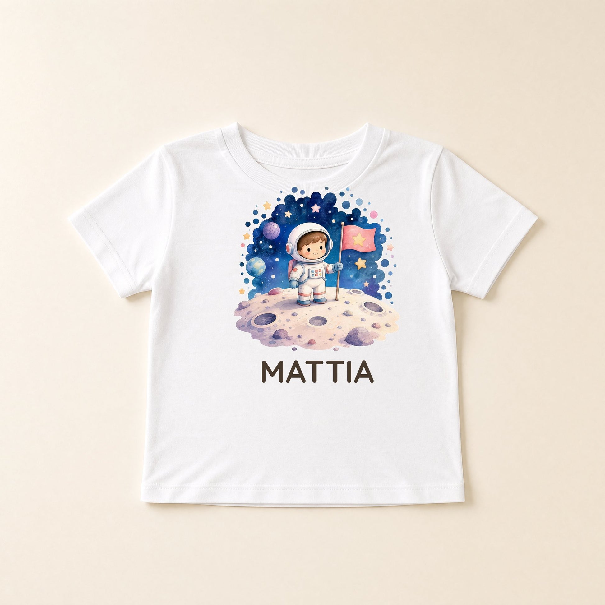 Maglietta bianca distesa con grafica a tema spazio e il nome Mattia