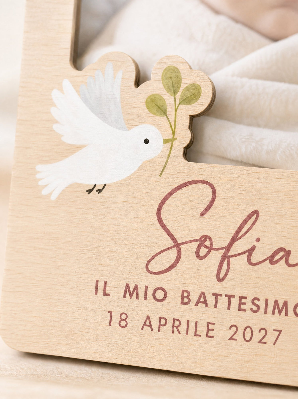 Dettaglio della colomba in legno e della scritta Sofia in rosa sul portafoto battesimo