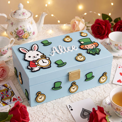 Coperchio di una scatola verde scuro con Alice e il Bianconiglio, cuori, orologi da taschino e il nome Alice in bianco
