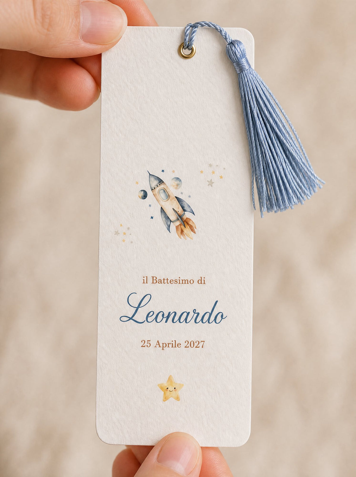 Retro del segnalibro con la scritta il Battesimo di Leonardo tenuto fra le dita