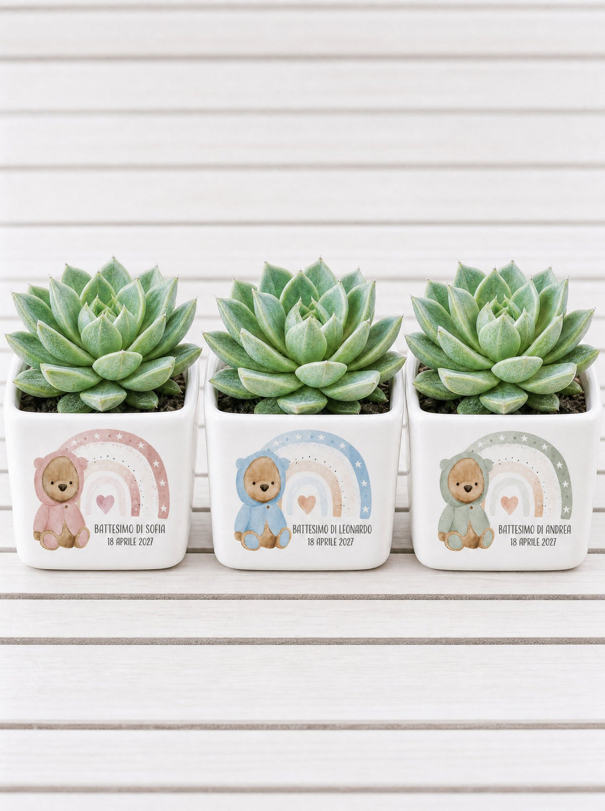 Tre vasetti in ceramica affiancati: rosa per Sofia, azzurro per Leonardo, verde salvia per Andrea